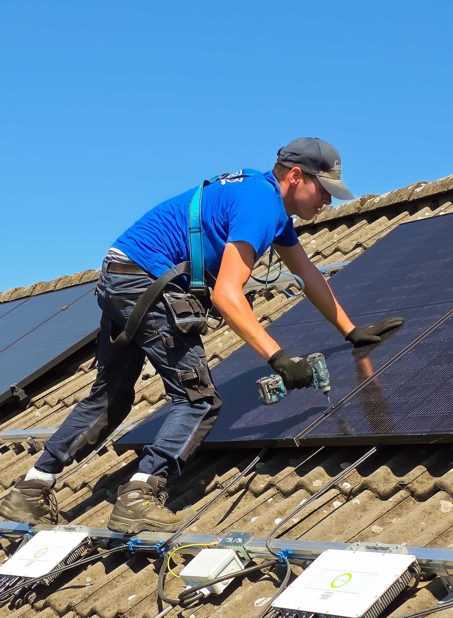 Monteur monteert zonnepanelen op een pannendak